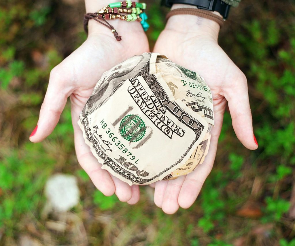 Twee handen die geld ophouden.